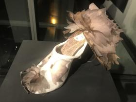 A white shoe with some light feathery leaves embellishments.