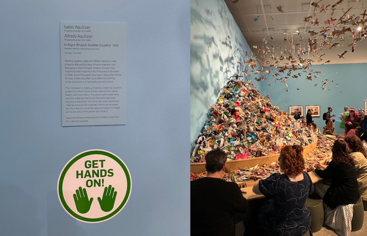 Gallery sign saying 'hands on' with people playing with artwork.