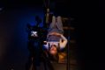 A young girl likes on her back on the floor with a movie camera above her. POV