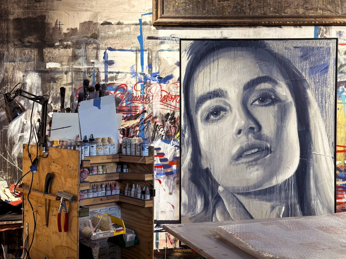 an artists' studio with paints and detritus and a large monochrome protrait of a woman with long hair. Open House Melbourne 2025