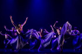 A group of dancers in flowing long skirts.