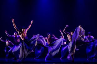 A group of dancers in flowing long skirts.