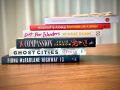 Six books in a stack on a table.
