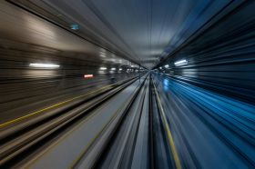 A photograph of a train passing through an underground tunnerl at high speed. The image is composed of fast-moving diagonal lines representing the train's rapid speed, and illustrates ArtsHub's weekly round up of Australian arts sector appointments, On the move.