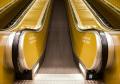 An escalator shot from the bottom with yellow sides. On the move.