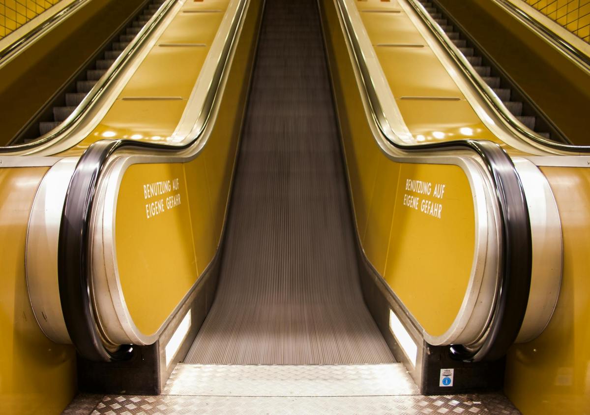 An escalator shot from the bottom with yellow sides. On the move.