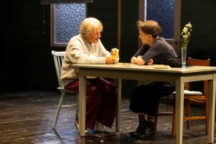 Two older woman sitting at a table.