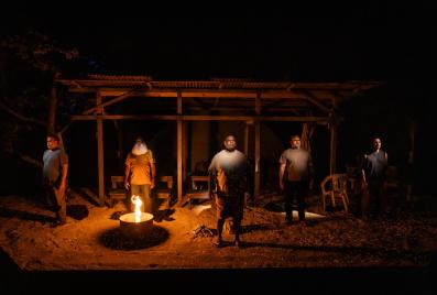 Five men stand in a sandy space with a fire pit in front of them. Dear Son. Bille Brown Theatre