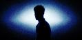 A silhouette of a man in white-blue light.