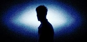 A silhouette of a man in white-blue light.