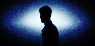 A silhouette of a man in white-blue light.