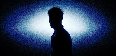 A silhouette of a man in white-blue light.