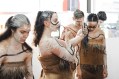group of female Indigenous dancers with one applying face ochre using phone. NAIDOC