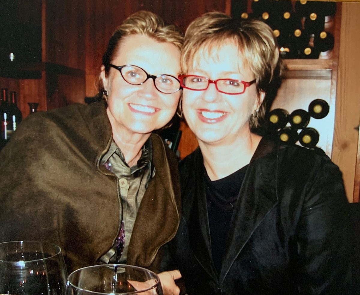 Two women wearing glasses are cheek to cheek. Cheryl Johnson and Judith Isherwood.