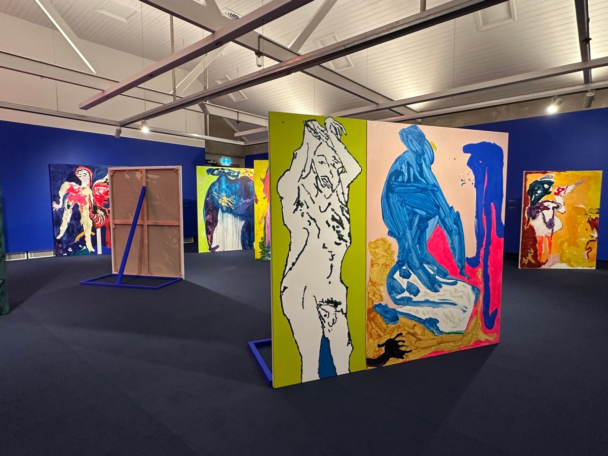 View of gallery installation with abstract colourful paintings, and blue gallery walls. Tom Polo