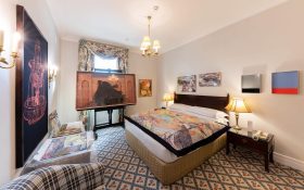 A comfortably furnished hotel room decorated with art as part of SPRING1883.