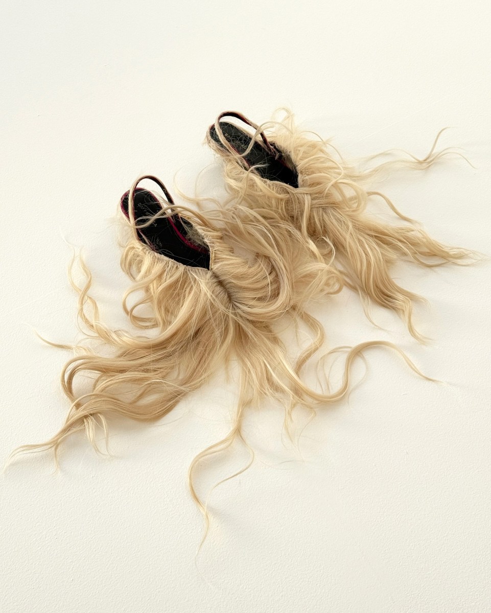 A pair of sling-back slippers decorated with blonde wigs. SPRING1883.