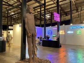 a tall wooden carving of a simian creature. Offering by Bernard Singleton. CIAF Art Awards 2025