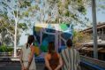 Three women with their backs to the camera admire a colourful mural, an emample of work supported by Regional Arts Development Orgsnisations in NSW.
