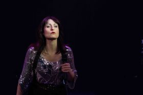 A woman with dark hair in a sparkly top. Loving The Alien.