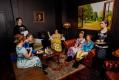 A group of people in Regency period costume in a parlour room. Plied and and Prejudice.