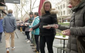 Photo of people passing books outdoors in the winter to help Hill of Content relocate their bookshop.
