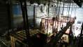 Theatre workers: a photograph of a theatre stage including the rafters, rigging and scaffolding structures above and behind the theatre stage.