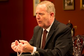 A side view of a man in a suit and tie in a production of The Gospel According to Paul.
