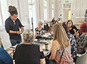 Pacific Island artist conducting a workshop with group. Watercolour Muster