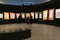 Gallery with black painted walls displaying Australian Aboriginal bark paintings. Yirrkala