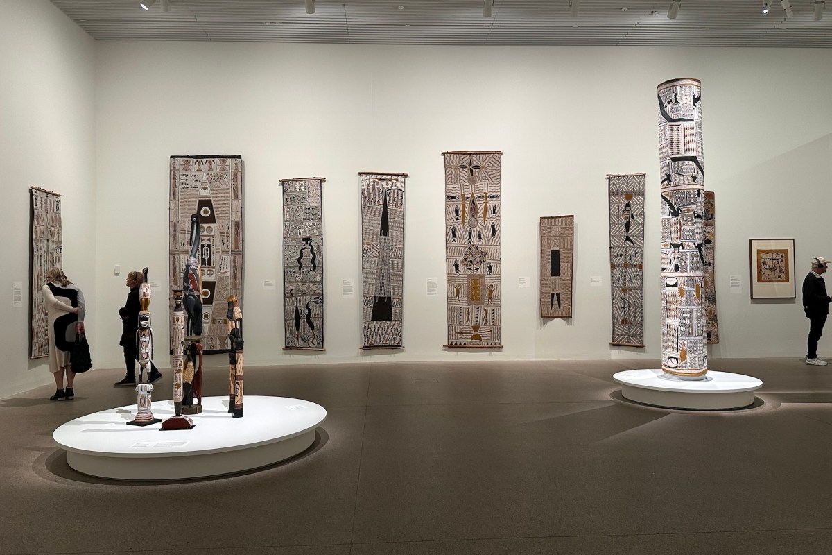 People in gallery with very large bark paintings by Aboriginal Australian artists. Yirrkala