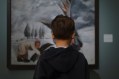 back view of a young male looking at a painting. Arts Vouchers for Kids.