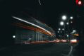 The lights of a bus down a dark street at night leave a trail of light to indicate rapid movement in this photograph, which illustrates ArtsHub's weekly On the move column, a round-up of the week's Australian arts sector appointments.