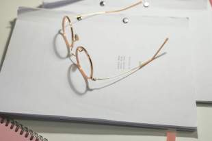 Writing Australia: a hardcopy of a manuscript on a table with a pair of glasses placed on top of the front page (birds eye view).