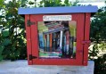 Red cabinet on street filled with free books. Street Libraries.