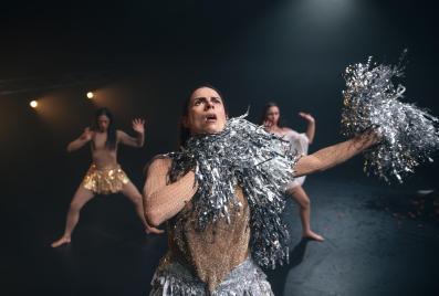 Four women in sparkly gold outfits dancing. Two have silver pom poms in a production of PHANTASM.