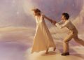 Promotional image for Opera Australia's 2026 production of 'La Bohème'. The photo shows a young woman in white walking away from a young man, who clings to her left hand as if imploting her to stay.