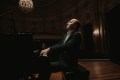 A man sitting at a piano. Alexander Gavrylyuk, concert pianist.