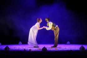 A man and a woman in Regency costume are holding hands and facing one another in Pride and Prejudice.