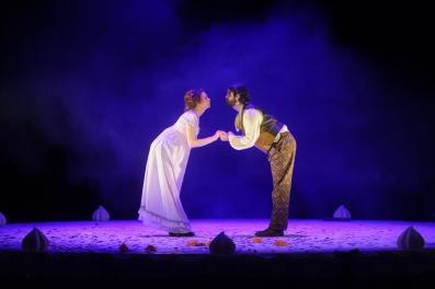 A man and a woman in Regency costume are holding hands and facing one another in Pride and Prejudice.