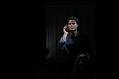 A man with holding a phone in his ear in the dark in Dial M for Murder.
