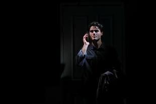 A man with holding a phone in his ear in the dark in Dial M for Murder.