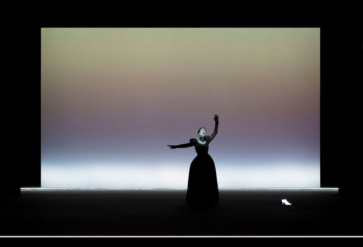 Isabelle Huppert in 'Mary Said What She Said,' exclusive to the 2026 Adelaide Festival. The photograph depicts Huppert in a stylised stage performance, her white-painted face distorted and her arms thrown out as she cries aloud in grief or anger.