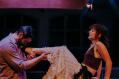A man cradling a woman's leg in a production of Miss Julie.