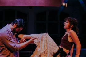 A man cradling a woman's leg in a production of Miss Julie.