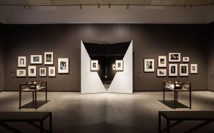 Small black and white photographers arranged in two clusters on either side of two mirrors, each with a small photographer in the centre. Man Ray and Max Dupain at Heide.
