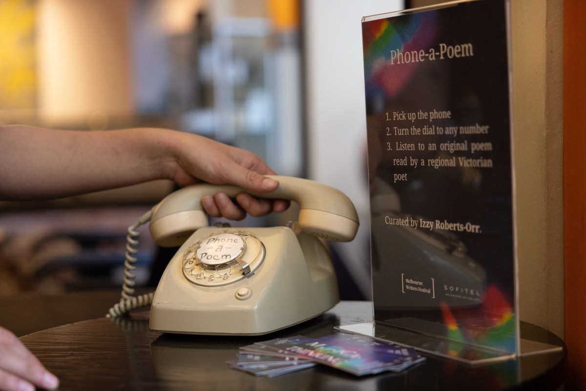 A hand on a rotary phone with a placard next to it saying 'Phone-a-Poem'. Taking Poetry off the Page.