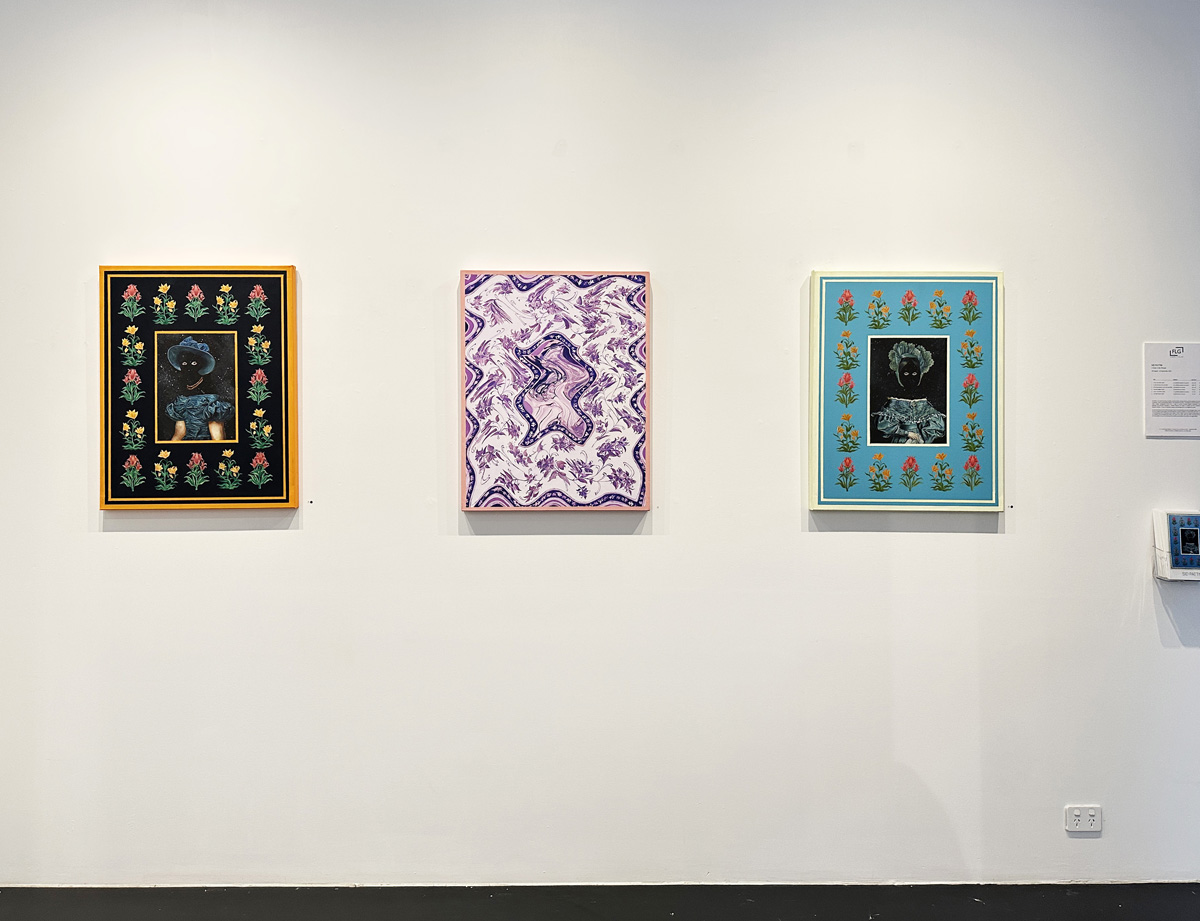 Three paintings hang on white gallery walls.