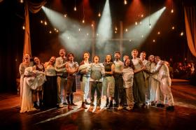 Fifteen performers on stage for the production of Songs for a New World.