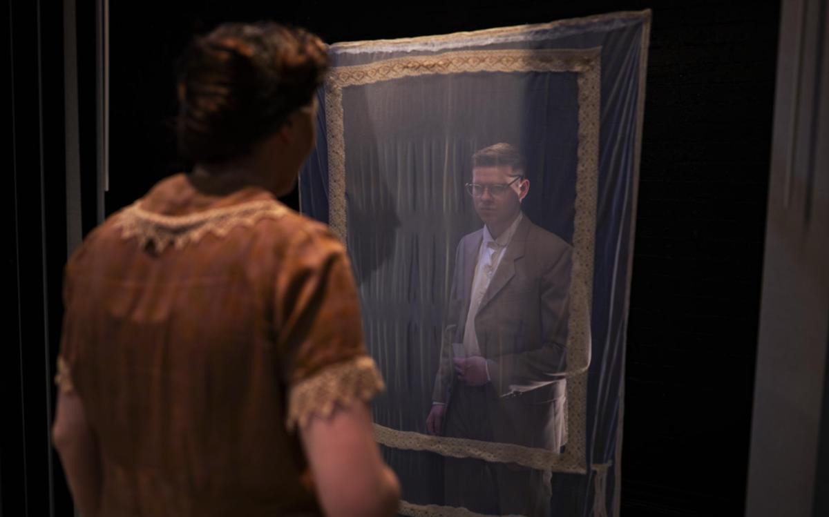 A woman is looking at a man through a veiled frame in Three Plays.